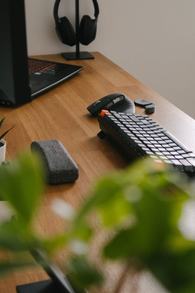 Aufgeräumter Arbeitstisch mit Tastatur, Maus und Laptop